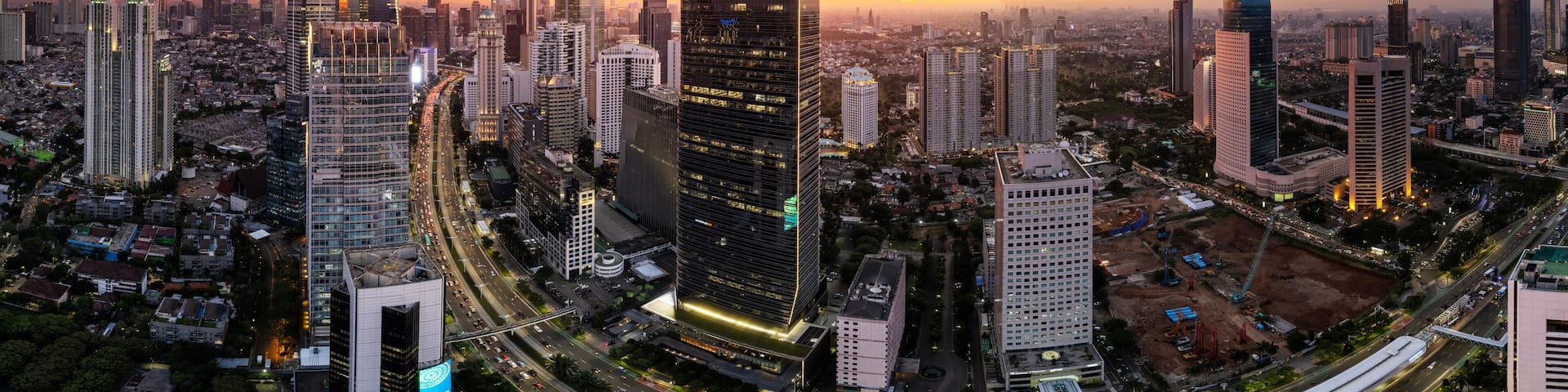 A cityscape with a prominent skyscraper and a sunset.
