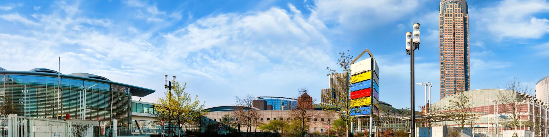 A modern urban landscape with a curved road, contemporary buildings, and a prominent tower.