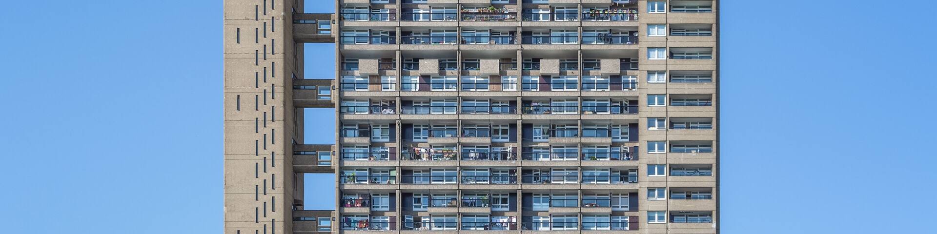 A tall, multi-story residential building with numerous balconies and windows.