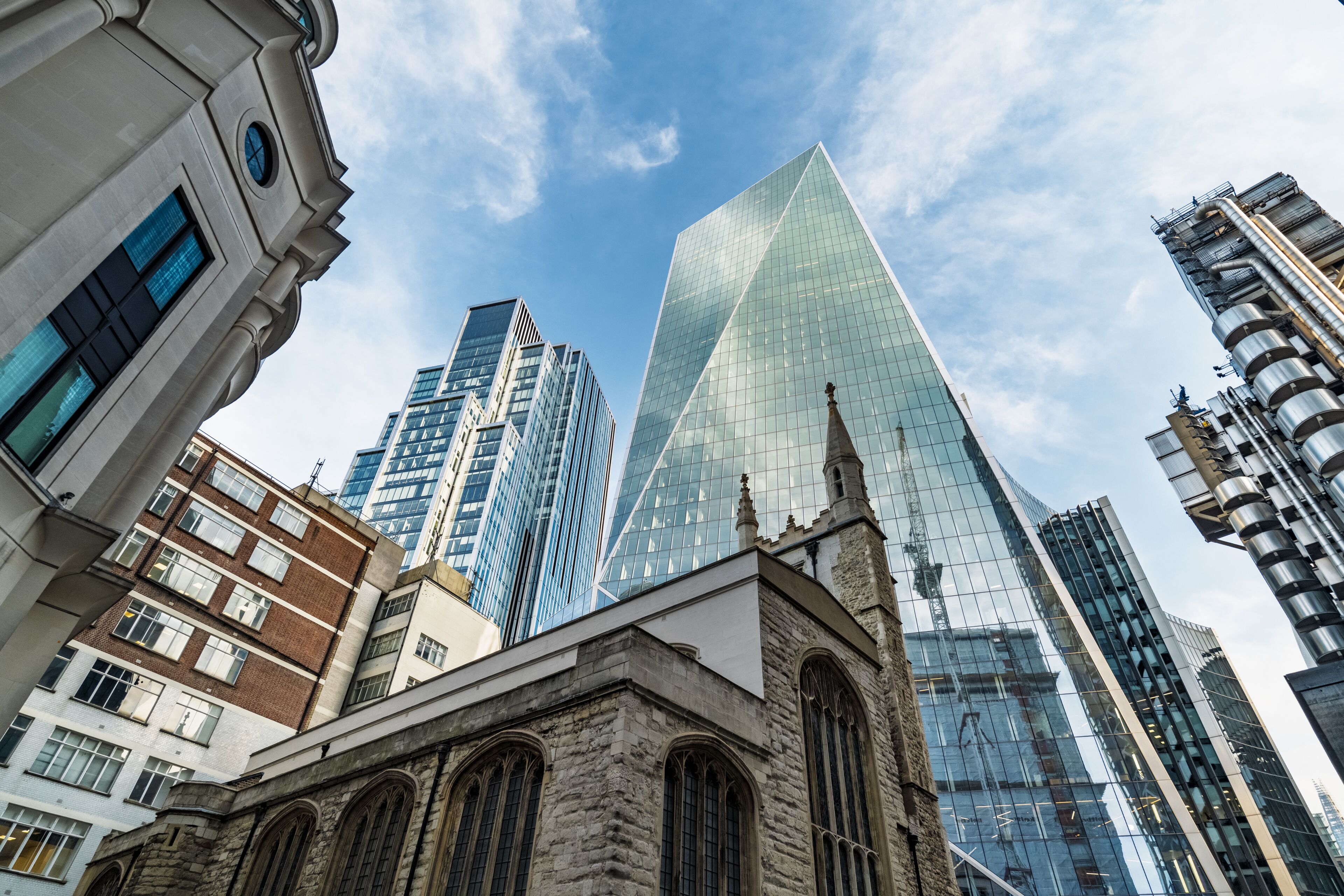 View of the historic St. Helen's Bishopsgate church juxtaposed with the modern glass facade of the Scalpel skyscraper in the City of London, London, England, United Kingdom.
