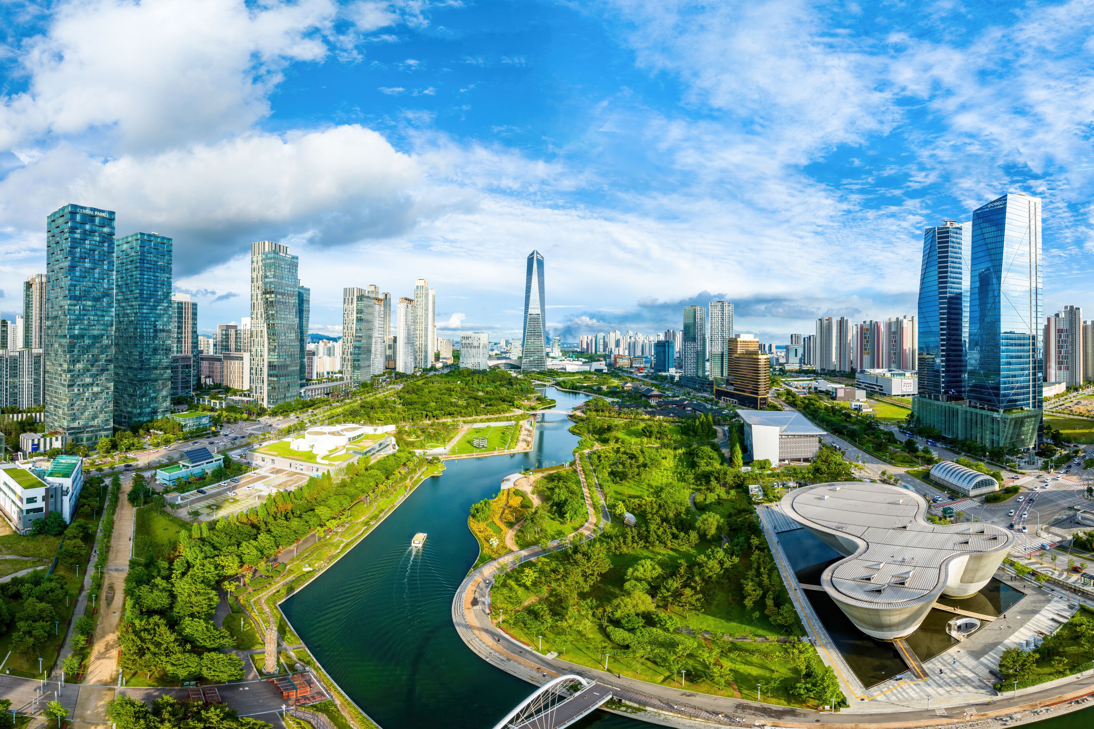 Songdo-dong, Yeonsu-gu, Incheon, South Korea - July 8, 2023: Aerial and summer view of Central Park with canal and Tri-bowl against apartments and Northeast Asia Trade Tower
