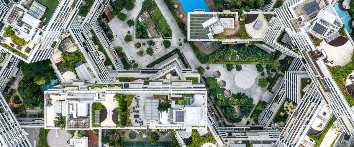 Aerial view of The Interlace residential complex featuring interconnected apartment blocks, lush rooftop gardens, and swimming pools in Singapore, Singapore.