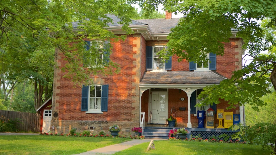 A brick house with blue shutters, a front porch, and a mailbox.