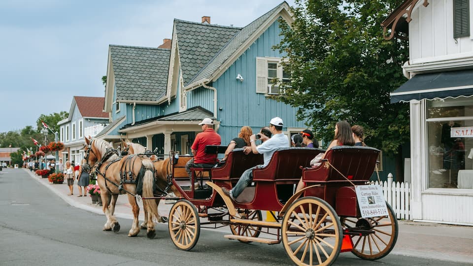 A horse-drawn carriage on a street lined with buildings.