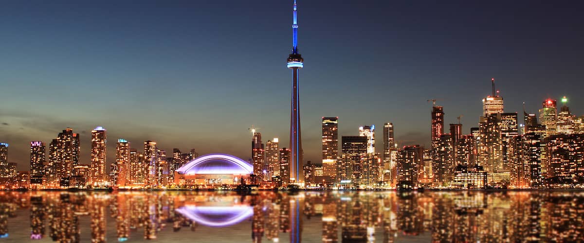 Toronto Skyline at night with a reflection in Lake Ontario.