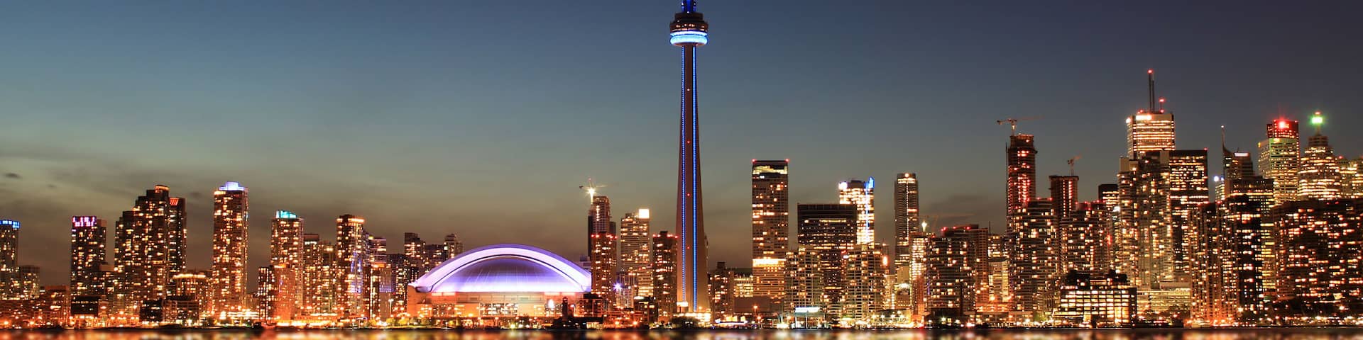 Toronto Skyline at night with a reflection in Lake Ontario.