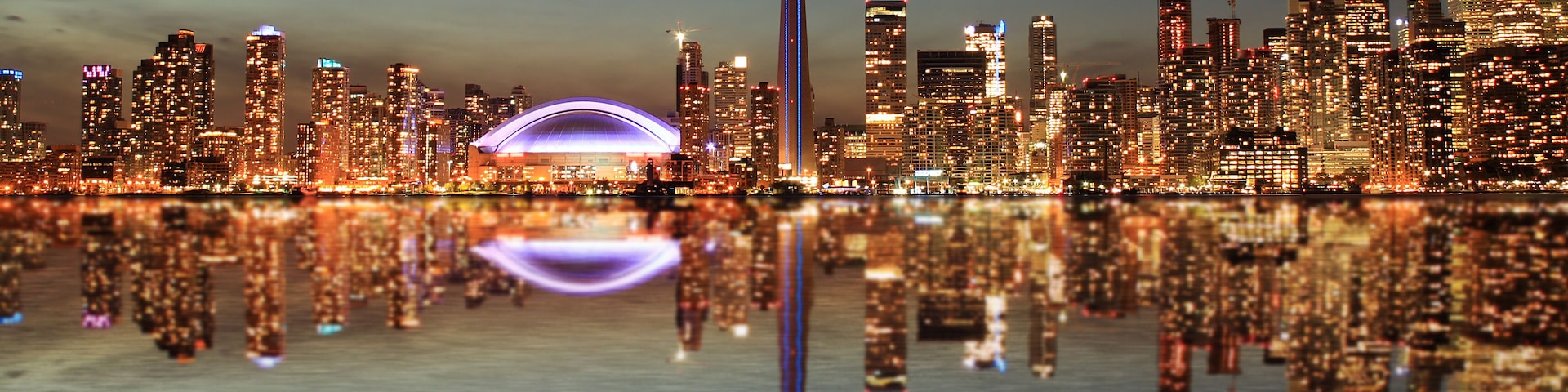 Toronto Skyline at night with a reflection in Lake Ontario.