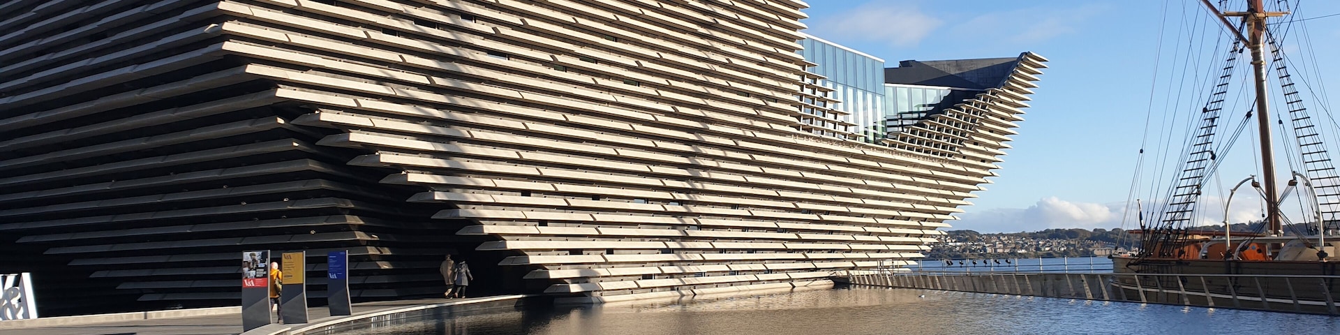 Un edificio de arquitectura moderna con un diseño de listones distintivo, ubicado junto a la costa.