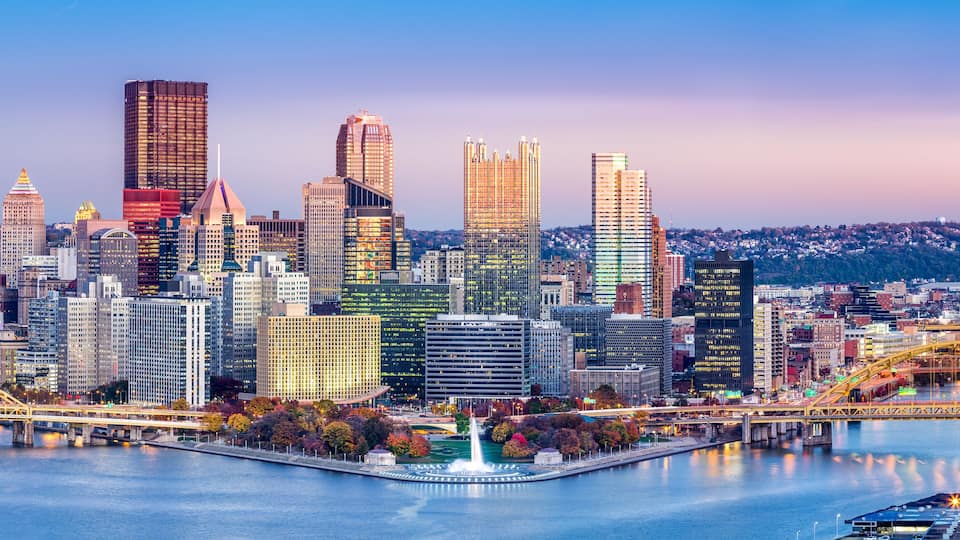 A city skyline with a river, bridges, and a variety of buildings.
