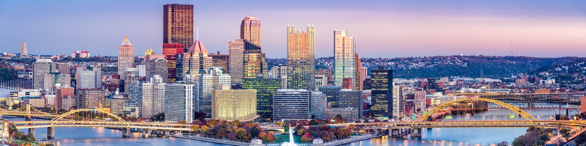 A city skyline with a river, bridges, and a variety of buildings.