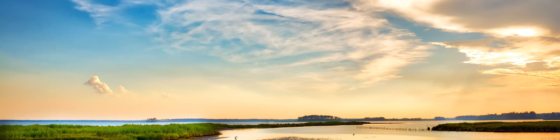 A calm lake with a clear sky and a distant shoreline.
