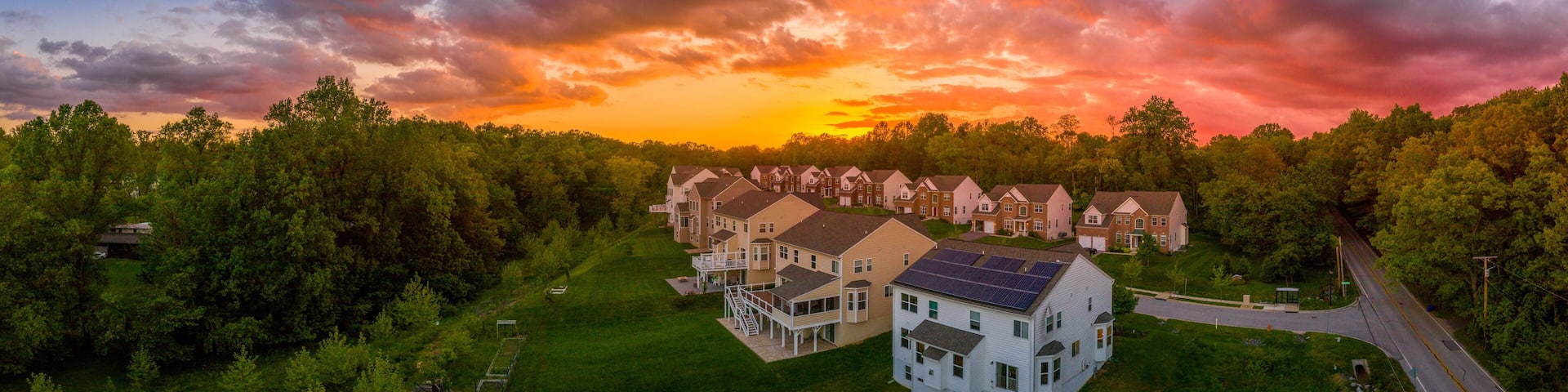 Modern American upper middle class single family homes neighborhood street with brick facade with solar panel in Columbia Maryland USA during sunset