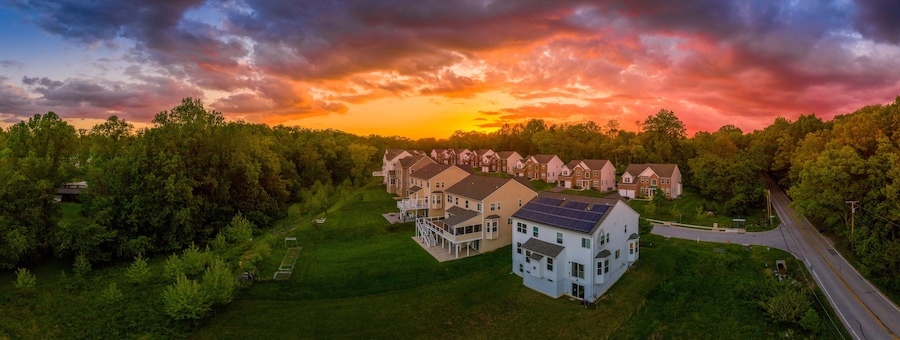 Modern American upper middle class single family homes neighborhood street with brick facade with solar panel in Columbia Maryland USA during sunset