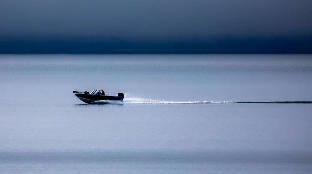 Two people in a fishing boat driving on Chequamegon Bay, on Lake Superior off of Washburn, Wisconsin in September