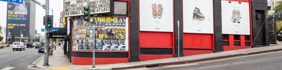 Un bâtiment rouge et noir, orné d’affiches et d’une enseigne sur laquelle on peut lire « Whisky a Go Go ».