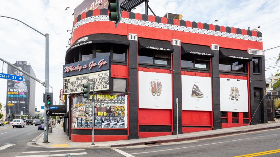 Un bâtiment rouge et noir, orné d’affiches et d’une enseigne sur laquelle on peut lire « Whisky a Go Go ».