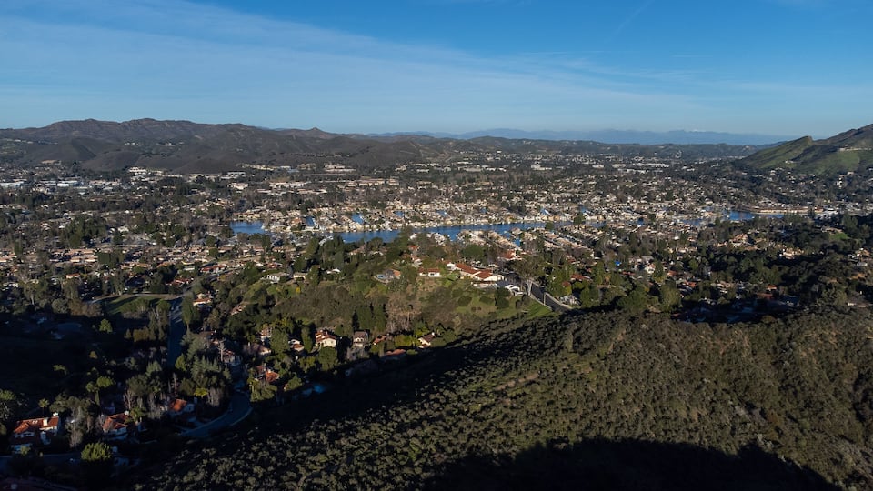 A coastal city with a bay, surrounded by hills and mountains.