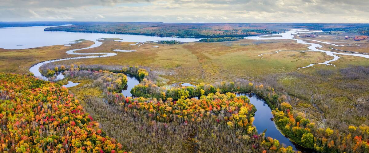 A river winding through a forest with autumn foliage.