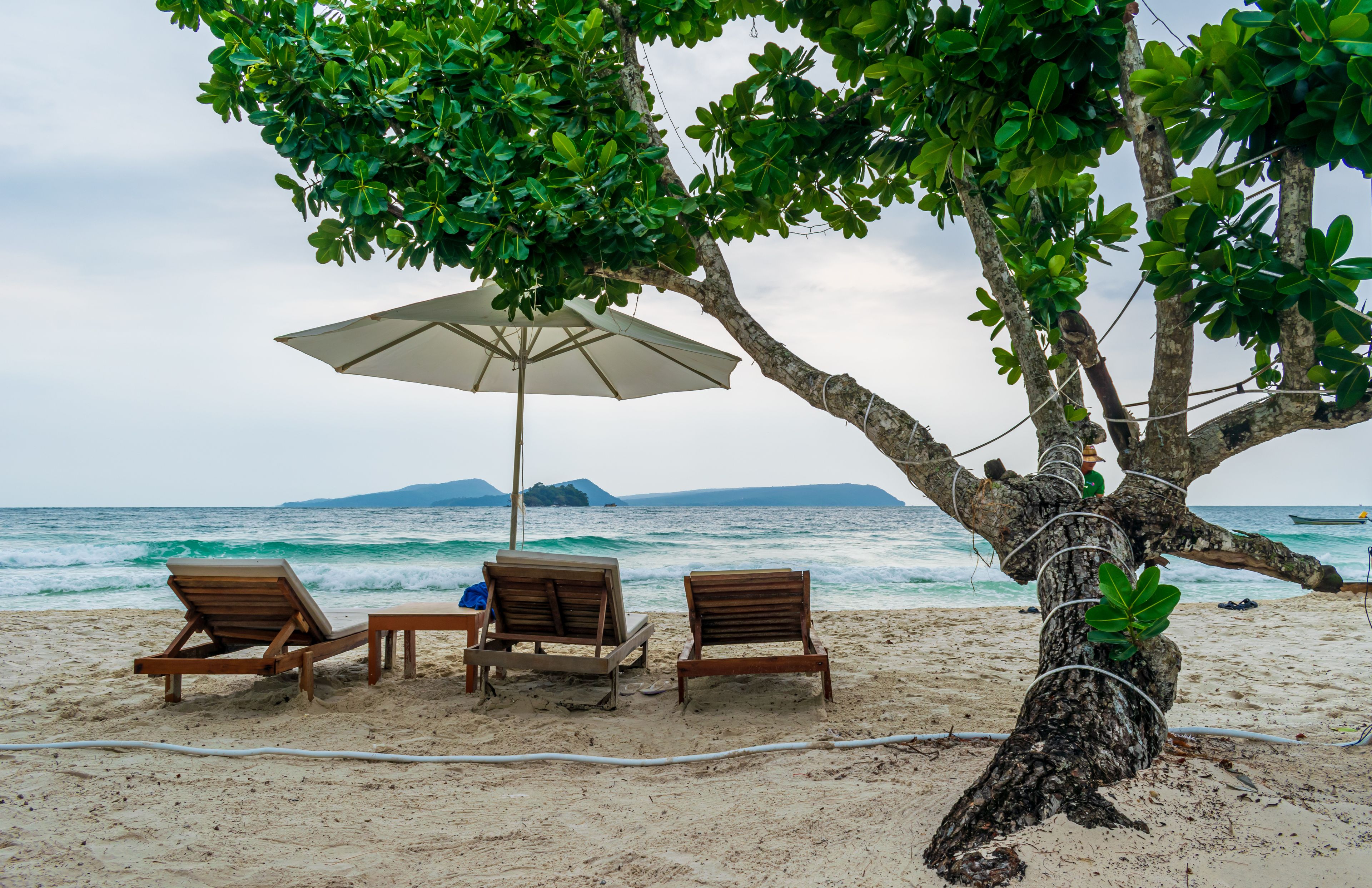 Beach chairs under a tree on the beach at the Longset Beach, Koh Rong, Cambodia