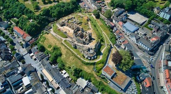 An aerial view of a historic site with ruins, surrounded by modern buildings and roads.