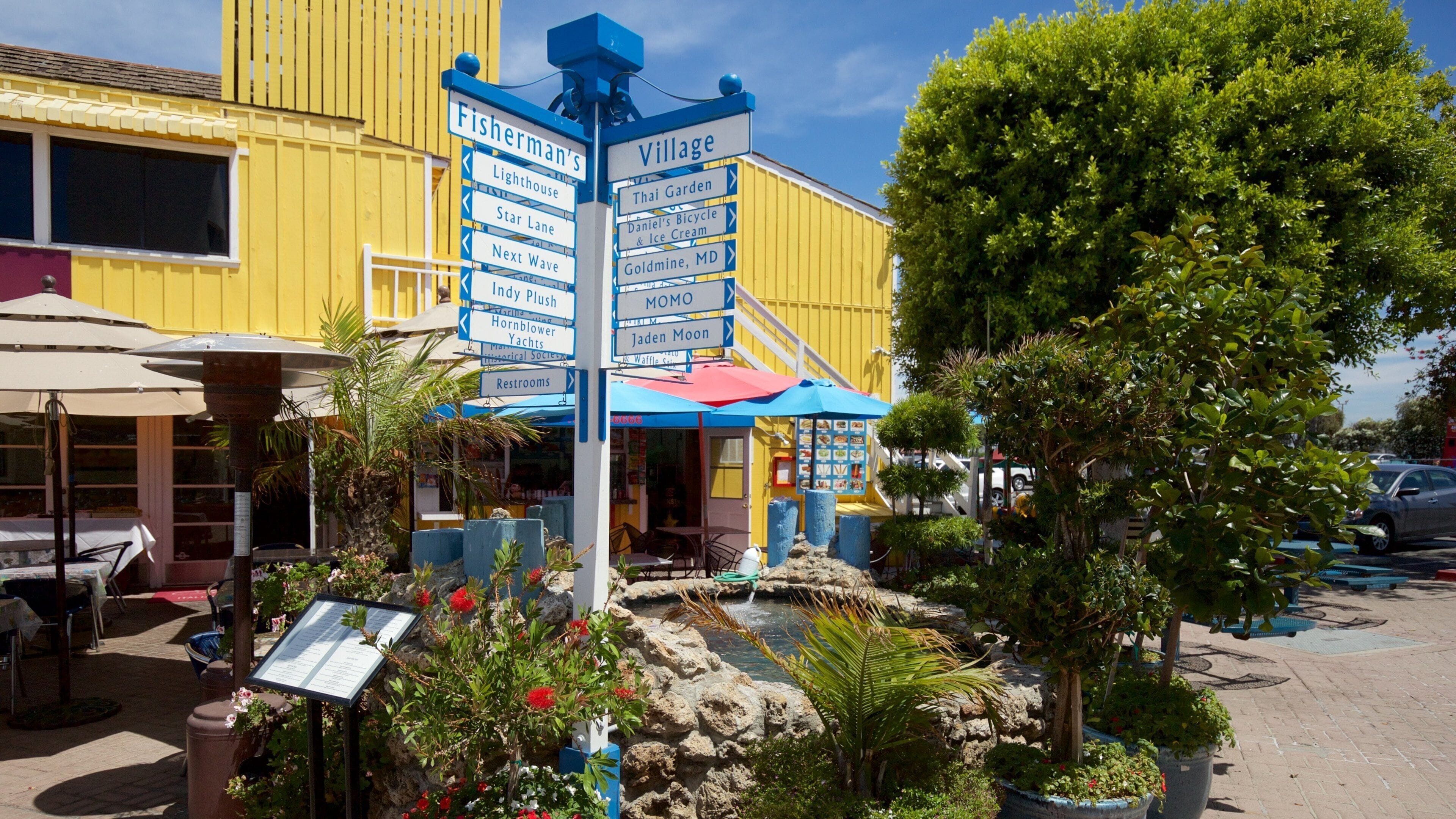 Un letrero colorido con indicaciones hacia varios atractivos turísticos locales.