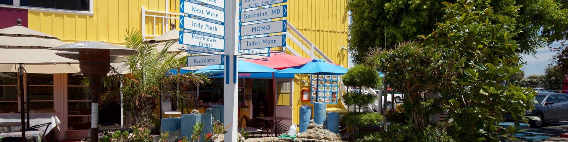Un letrero colorido con indicaciones hacia varios atractivos turísticos locales.
