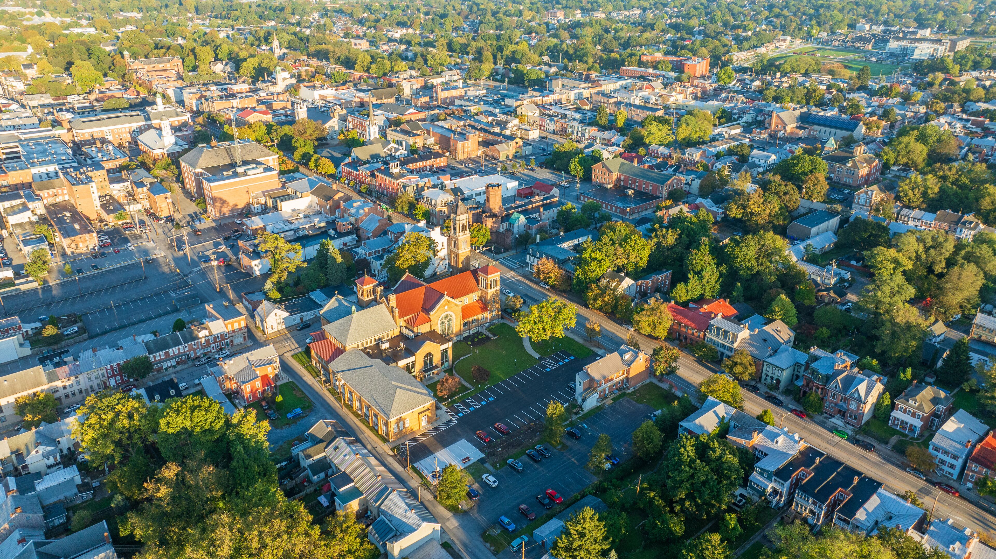 Aerial view of Carlisle, PA, showcasing a mix of residential, commercial buildings, and tree-lined streets under a clear morning sky.