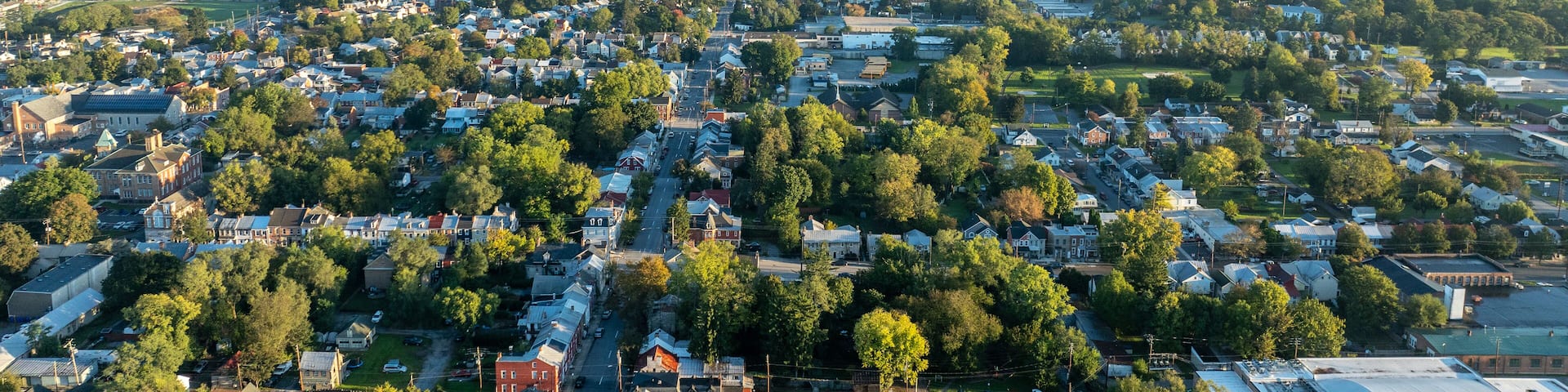 Aerial view of Carlisle, PA, showcasing a mix of residential, commercial buildings, and tree-lined streets under a clear morning sky.