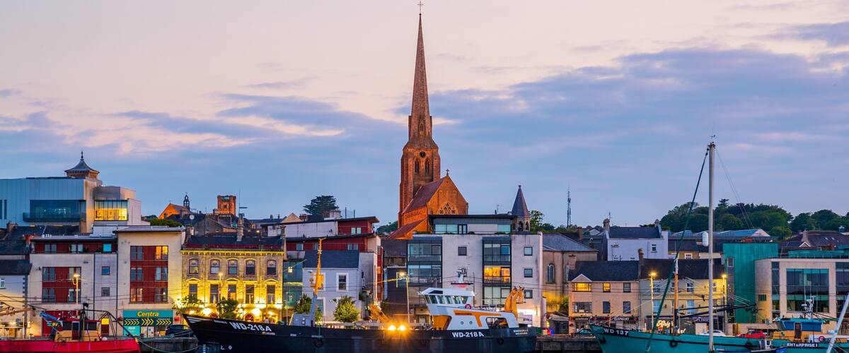 A harbor with boats, a church spire, and buildings.