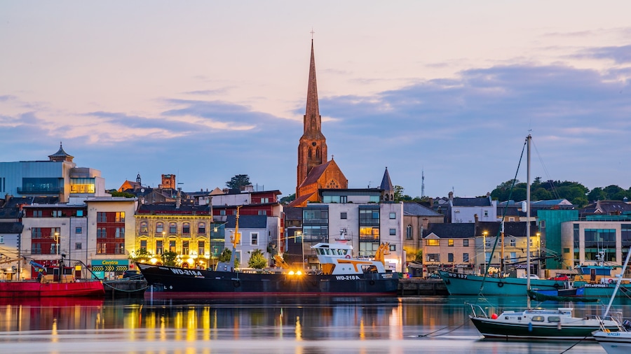 A harbor with boats, a church spire, and buildings.