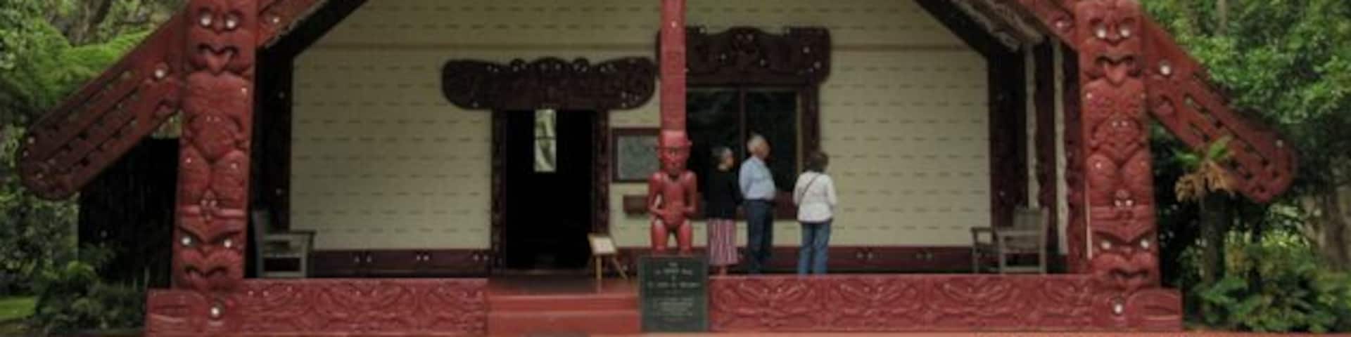 A red-roofed building with intricate carvings and a statue on top.