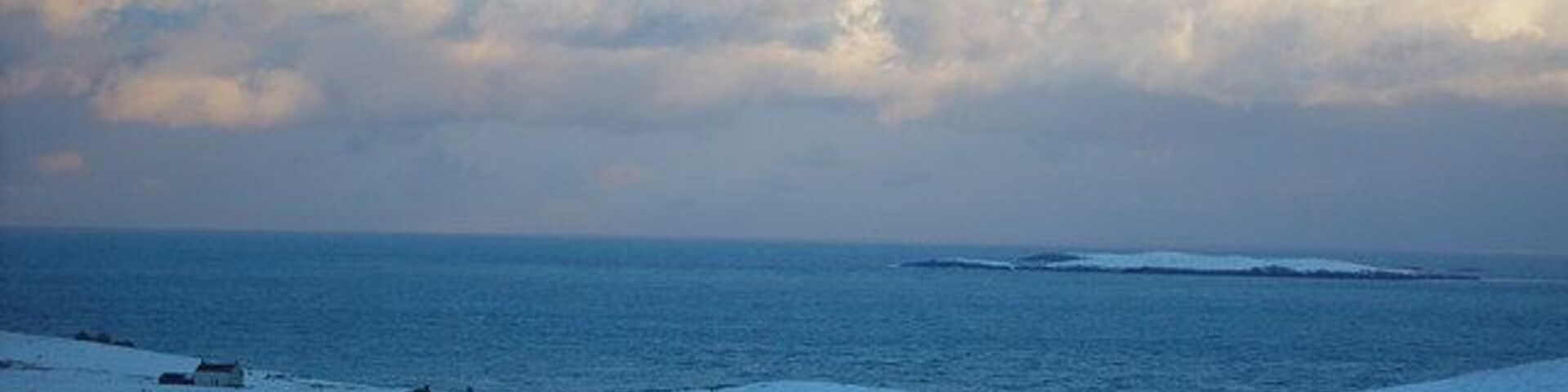 Treawick, Whalsay, Shetland. Croft houses at Treawick are no longer lived in. In the 1930s when the road from Symbister to Isbister was being planned the families at Treawick didn't want the road through their community as they thought it would change them. The road by-passed Treawick. The families later moved out to other parts of Whalsay. In the background are the islets of Flaeshans of Rumble and Rumble