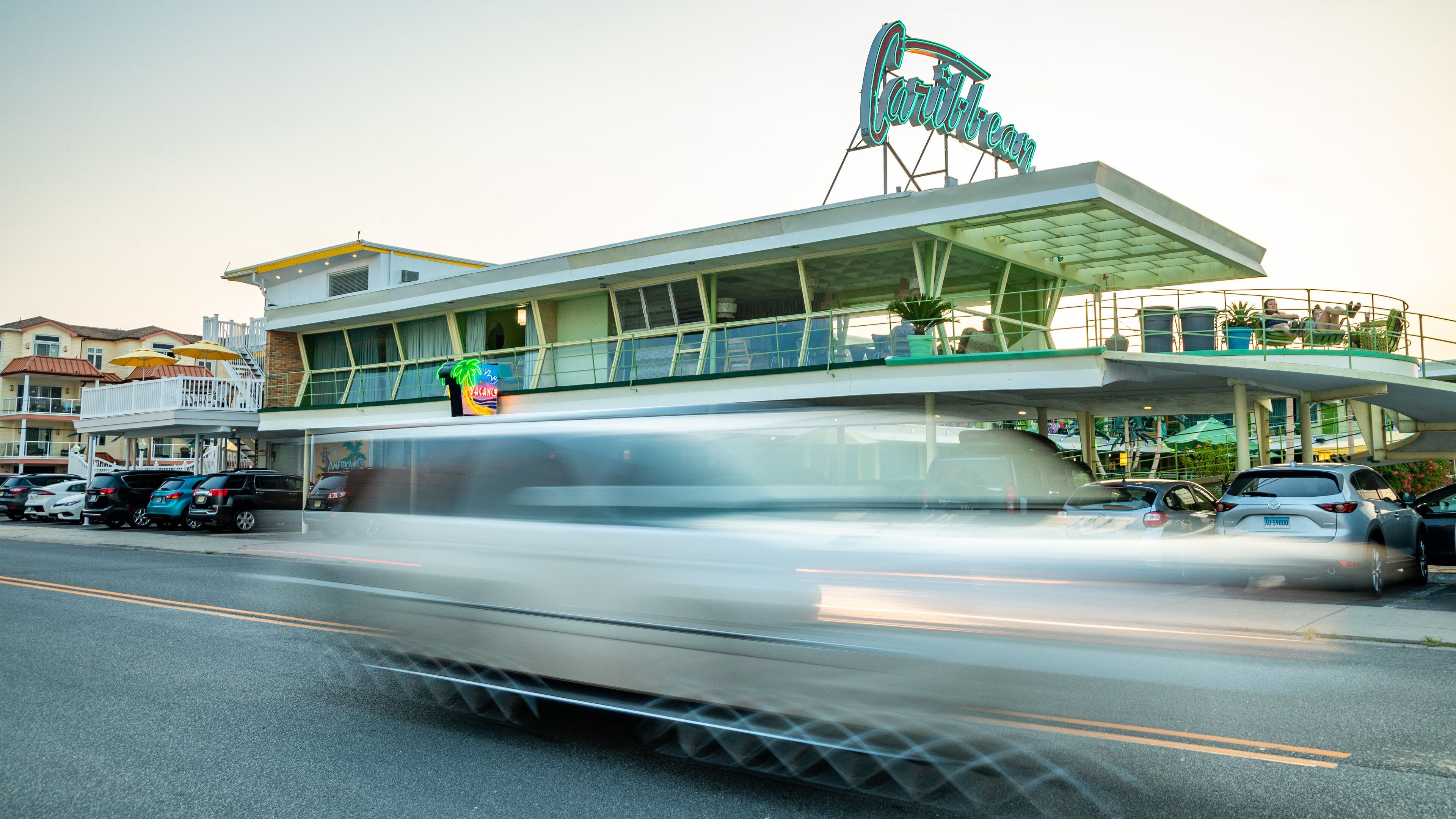 A trolley moving along a track with a building in the background.