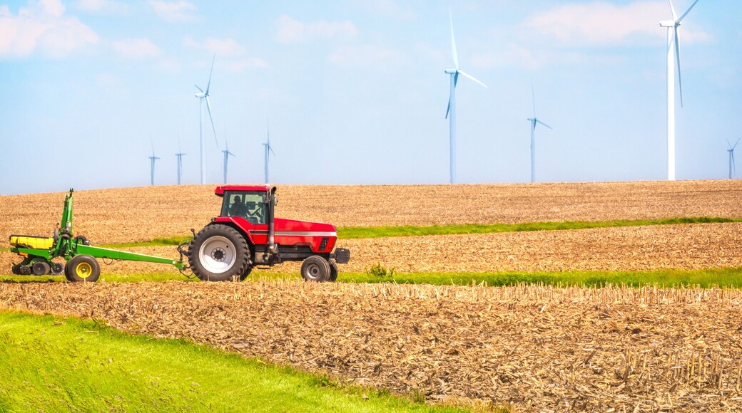 USA farmer farming with tractor on wind farm Danville Illinois