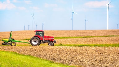 USA farmer farming with tractor on wind farm Danville Illinois