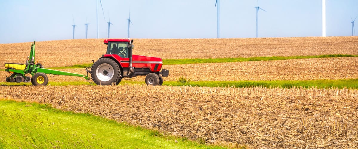 USA farmer farming with tractor on wind farm Danville Illinois