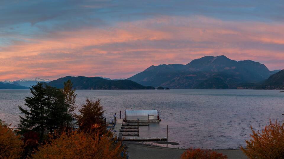 A lake with mountains in the background and a dock in the foreground.
