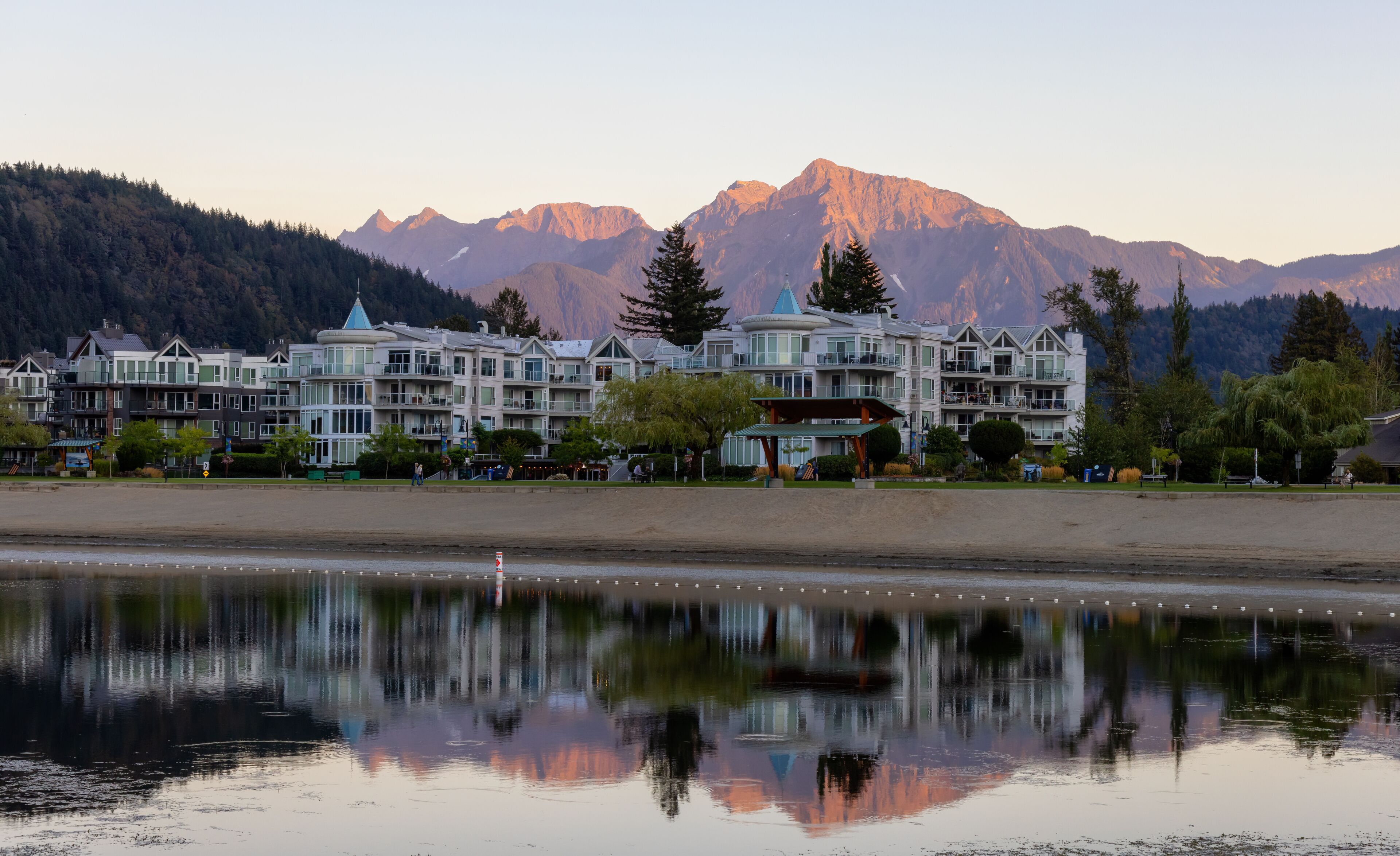 Vacation Homes by the lake and sandy beach. Sunny Summer Morning Sunset Sky. Harrison Hot Springs, British Columbia, Canada.