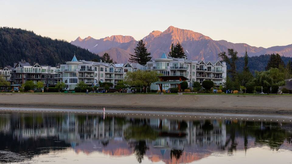 Vacation Homes by the lake and sandy beach. Sunny Summer Morning Sunset Sky. Harrison Hot Springs, British Columbia, Canada.