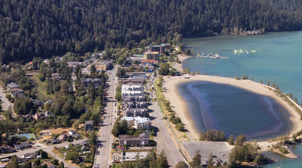 Small touristic town by the lake with Canadian Mountain Landscape. Sunny Summer Day. Harrison Hot Springs, British Columbia, Canada.