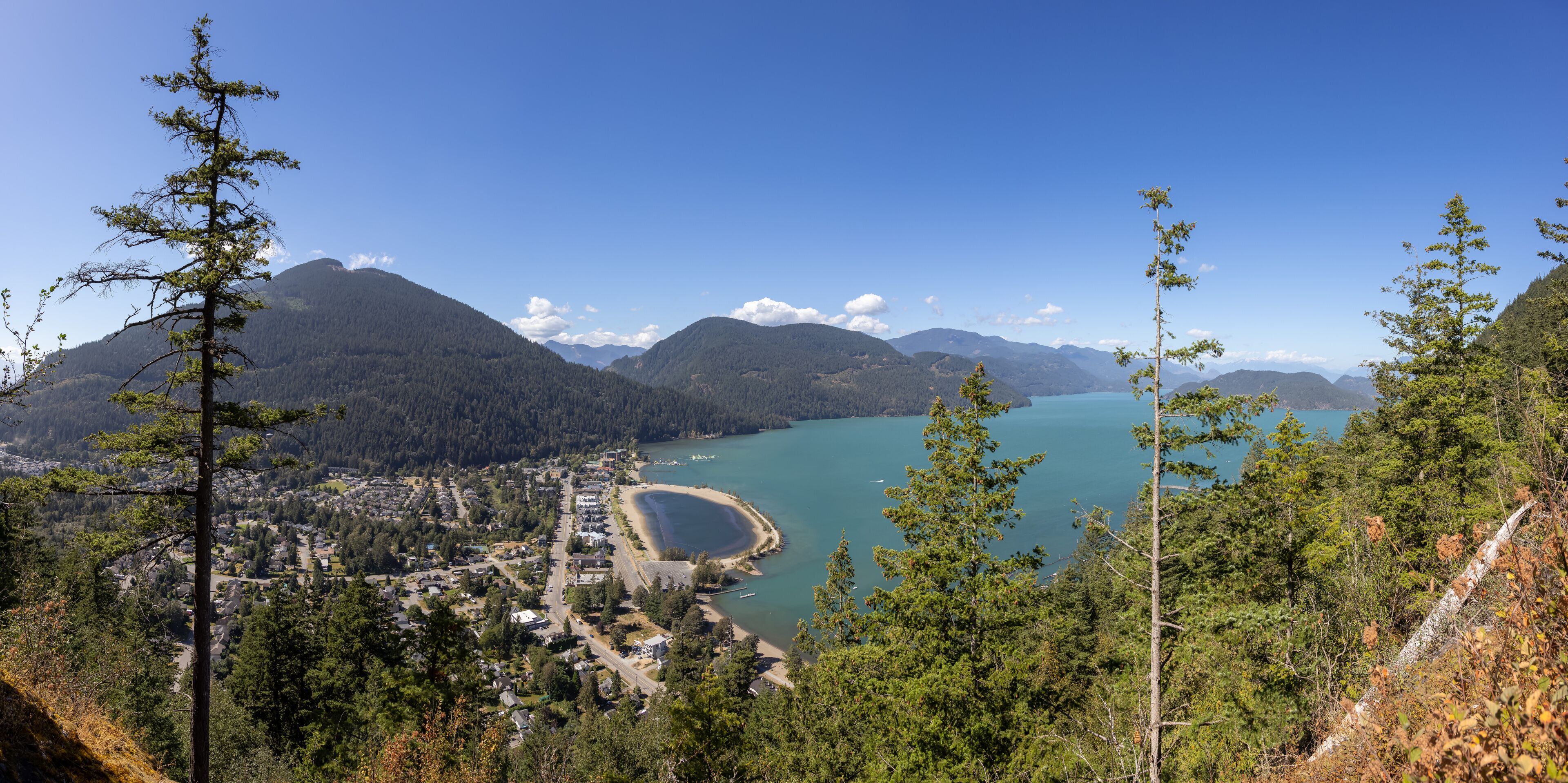 Panoramic View of Small touristic town by the lake with Canadian Mountain Landscape. Sunny Summer Day. Harrison Hot Springs, British Columbia, Canada. Panorama