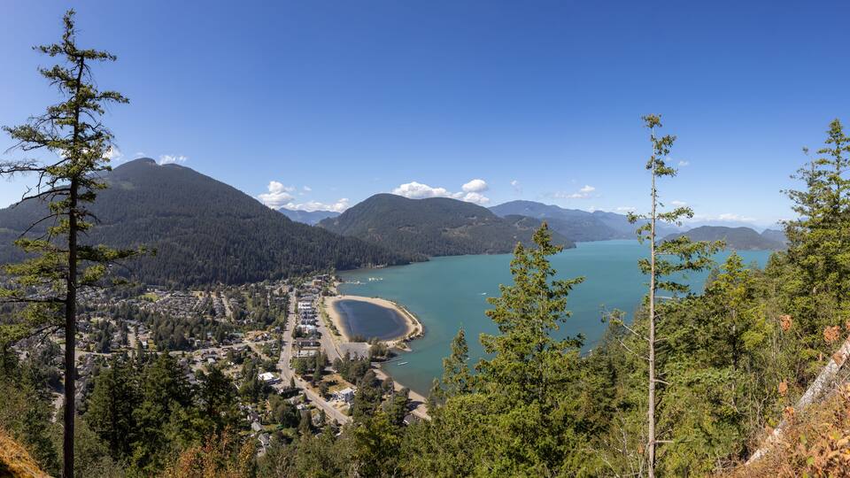 Panoramic View of Small touristic town by the lake with Canadian Mountain Landscape. Sunny Summer Day. Harrison Hot Springs, British Columbia, Canada. Panorama