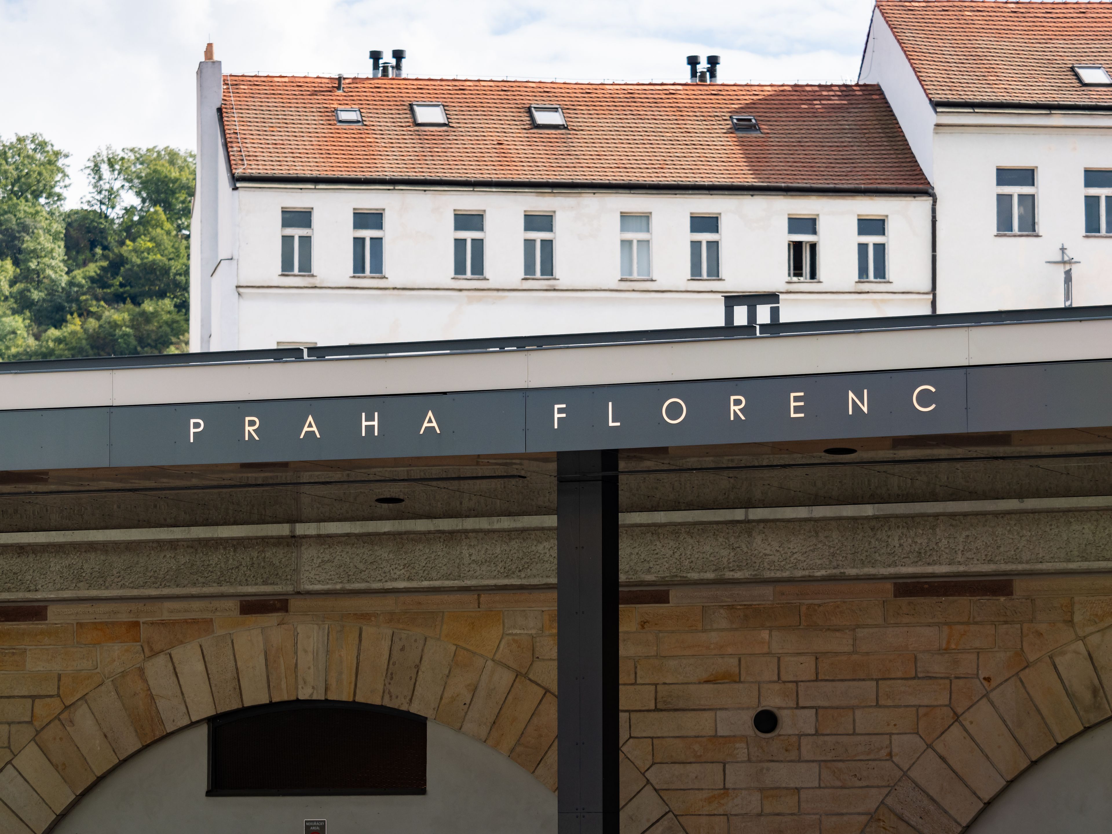 Un edificio con el cartel 'PRAHA FLORENC' sobre una entrada en arco.