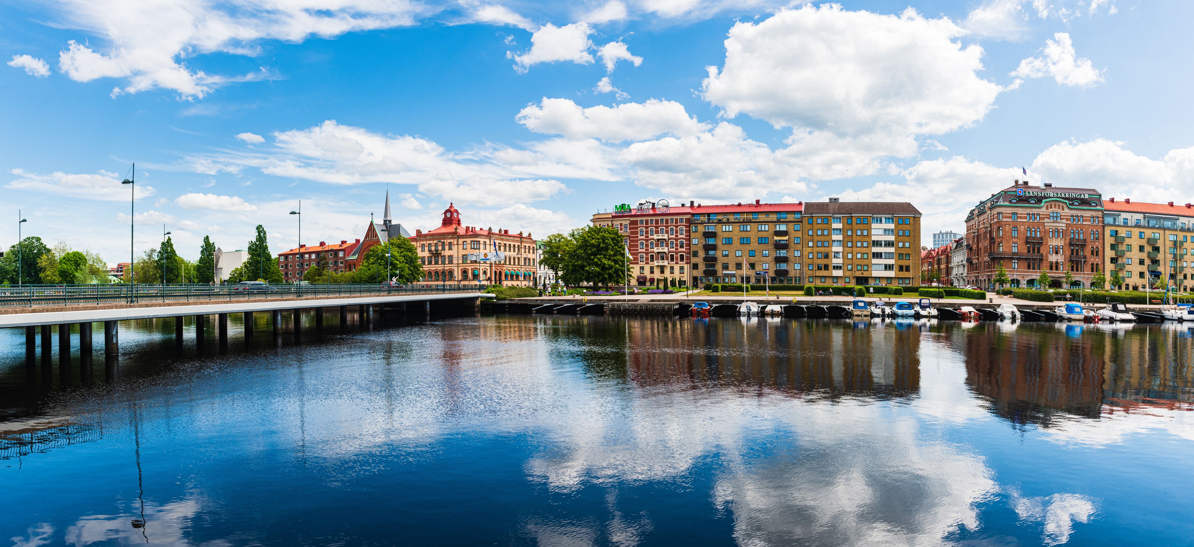 A waterfront with a bridge, buildings, and boats.