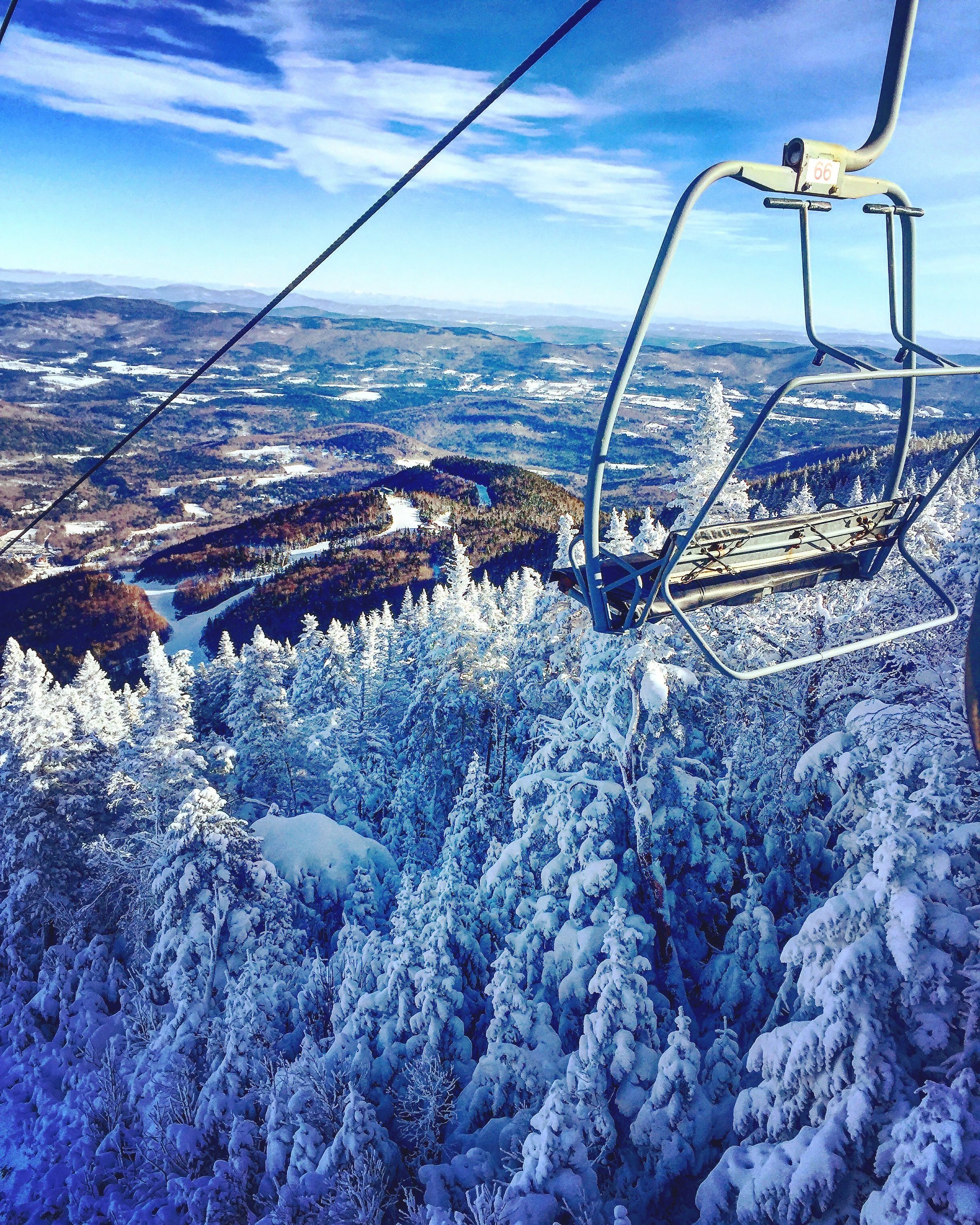 Chairlift on a mountain in Vermont with snow covered trees and the Mad River Valley