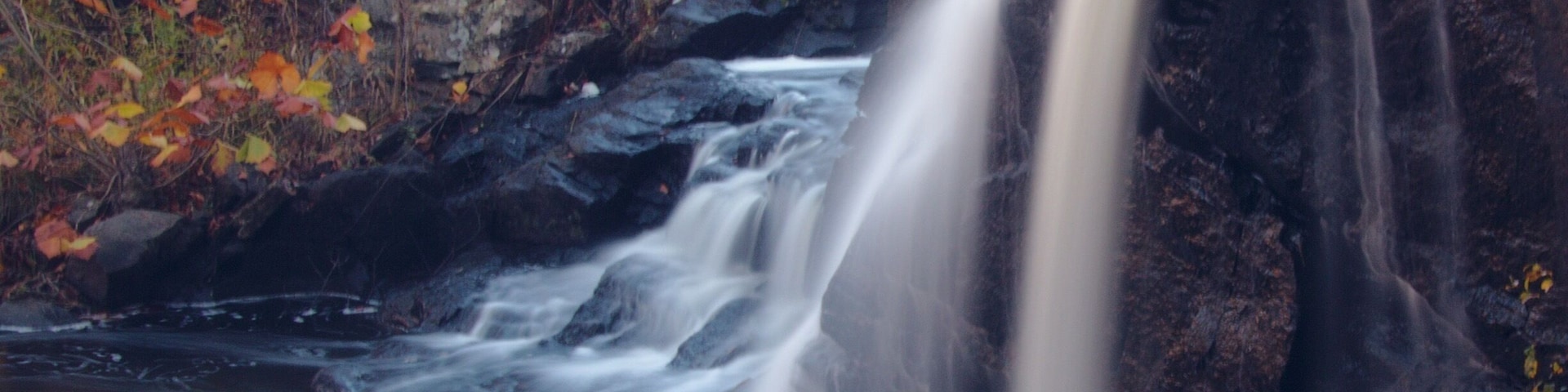 State park with a pretty waterfall and a covered bridge.