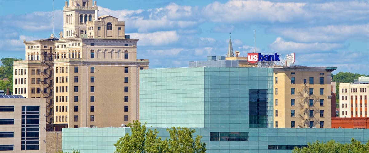 A historic building with a clock tower and a modern glass building with a US Bank sign.