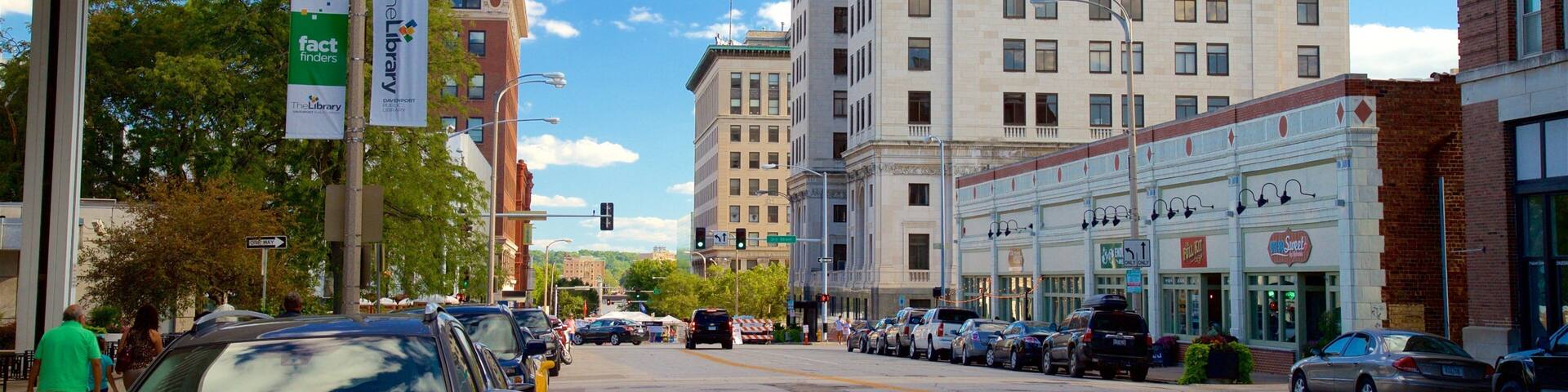 A city street with buildings, cars, and a clear sky.