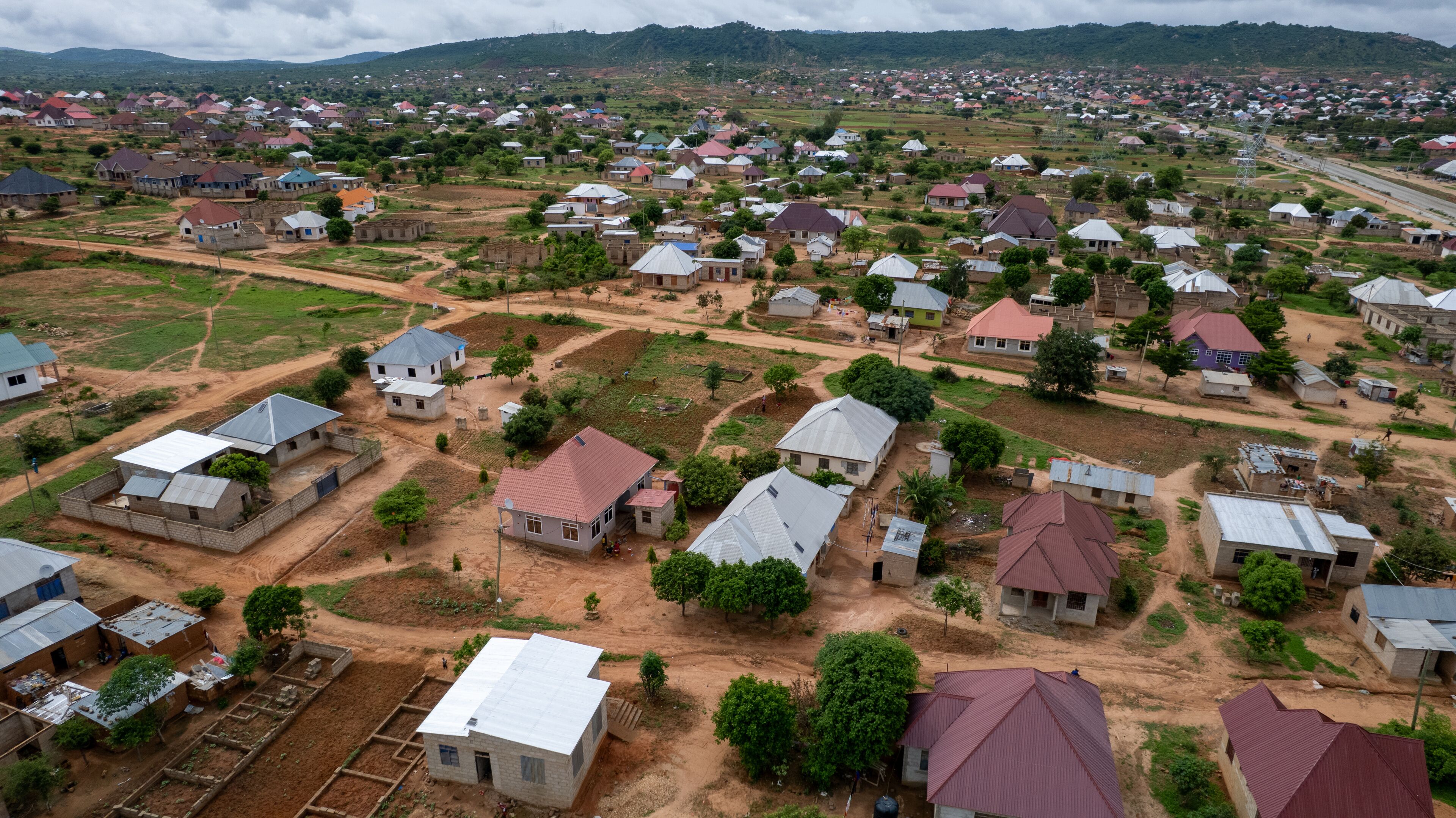 A rural settlement with houses, roads, and surrounding greenery.