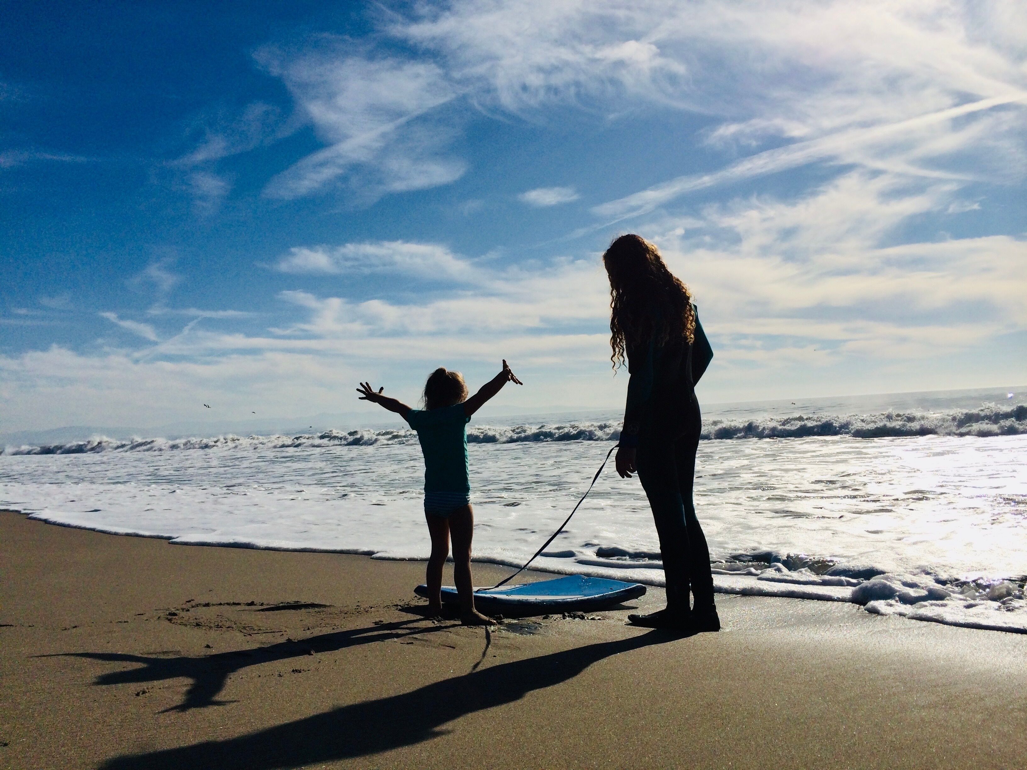 Silhouette of a mother teaching her daughter to Boogie Board, Rio Del Mar State Beach, Aptos, Santa Cruz, California, USA